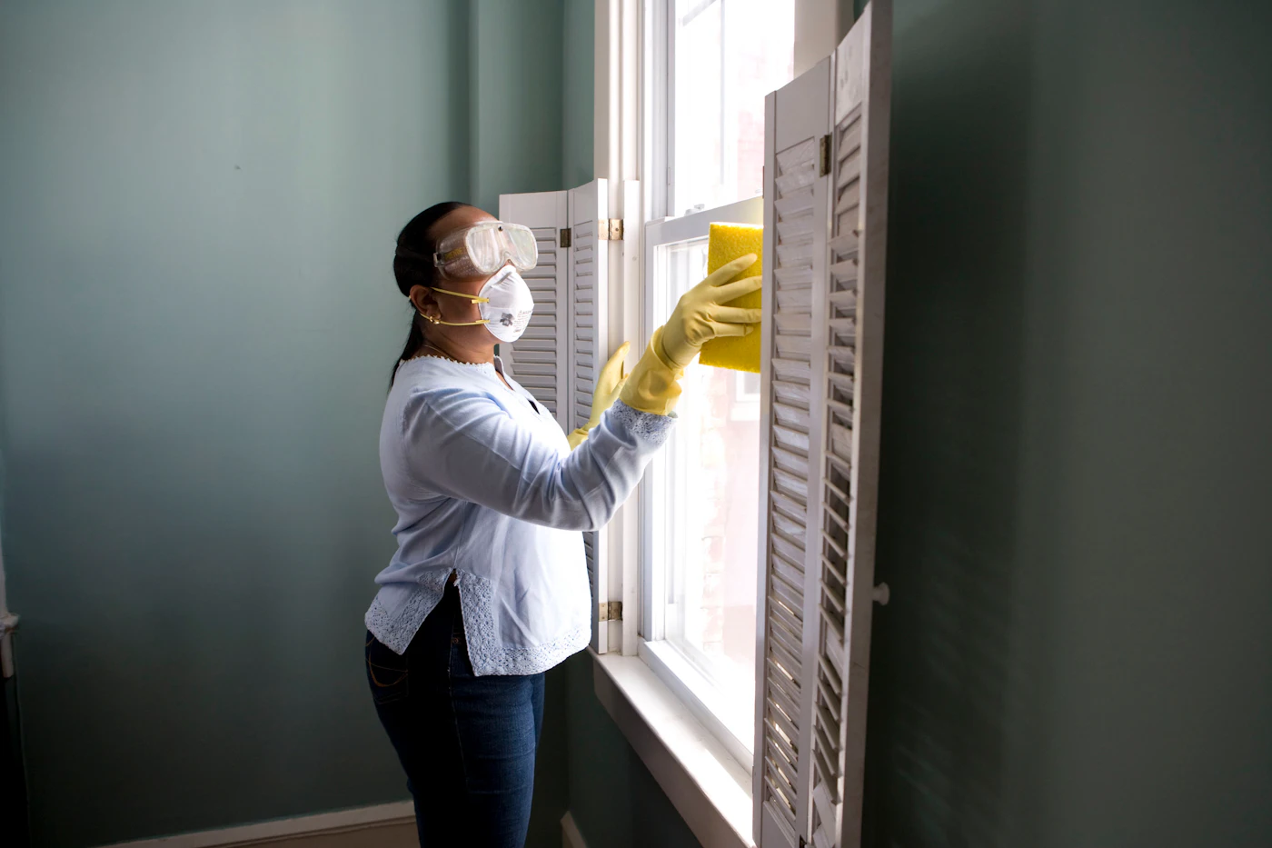 Magica Maids professional cleaner cleaning a window